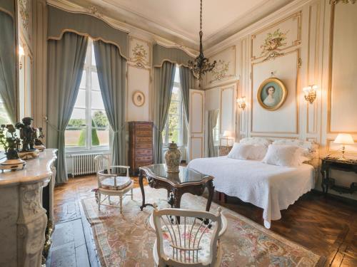 - une chambre avec un lit, une table et des chaises dans l'établissement Château de Boucéel - Mont Saint Michel, à Vergoncey