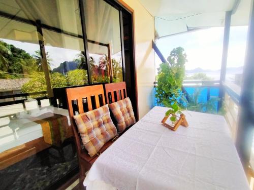 a table and chairs in a room with a window at Hwan Dynasty Suite in El Nido