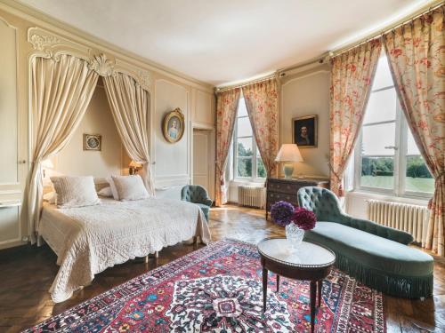 a bedroom with a bed and a couch and a table at Château de Boucéel - Mont Saint Michel in Vergoncey