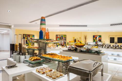 Un buffet con diversos pasteles y otros alimentos. en Alreem Village Hotel, en Al Jubail