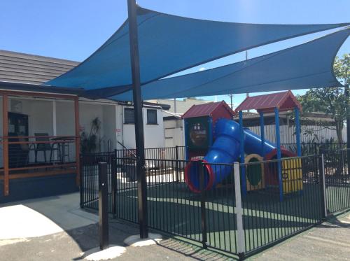 a playground with a blue umbrella next to a playground at Blackwater Hotel Motel in Blackwater