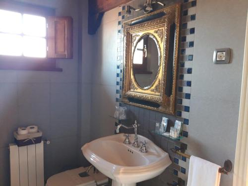 a bathroom with a sink and a mirror on the wall at Posada El Hidalgo in Valdecilla