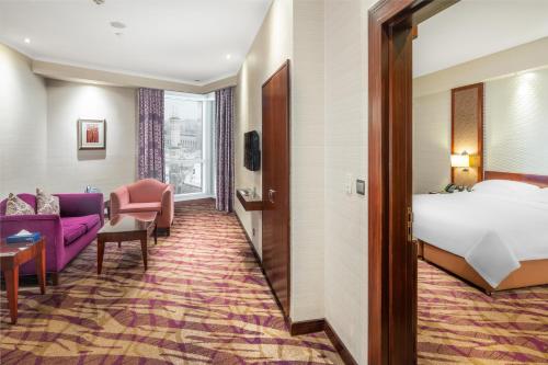 a hotel room with a bed and a couch at Al Marwa Rayhaan by Rotana - Makkah in Makkah