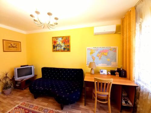 a living room with a desk with a chair and a couch at "В центре города" Квартира - "Downtown" Apartment in Almaty