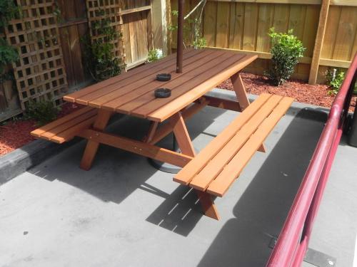 a picnic table with two benches sitting on a patio at St Georges Motor Inn in Melbourne