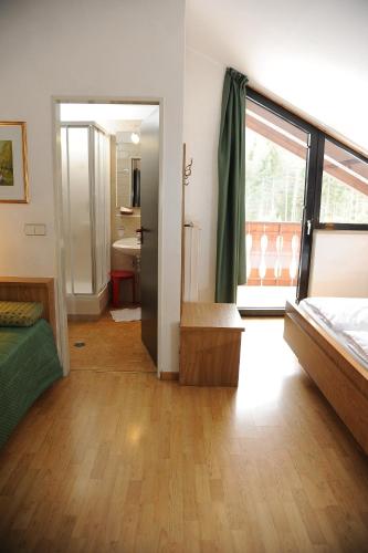 a room with a bedroom with a bed and a bathroom at Hotel Sole Family Hotel in Predazzo