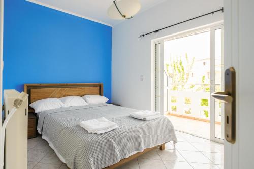 a blue bedroom with a bed with towels on it at Casa Galini - 25m from Beach Deluxe Apartment in Kalyves