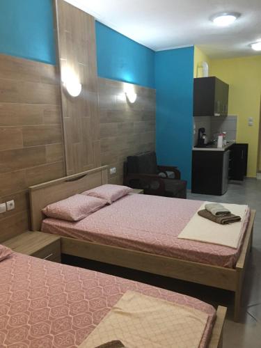 a room with two beds and a chair at G M 2 ROOMS KENTRO in the heart of the city in Larisa