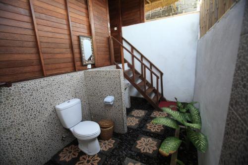 a bathroom with a toilet and a staircase at Sunset Coin Lembongan in Nusa Lembongan