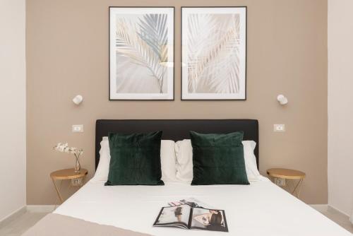 a bedroom with a bed with two pictures on the wall at White Flat Santa Croce in Rome