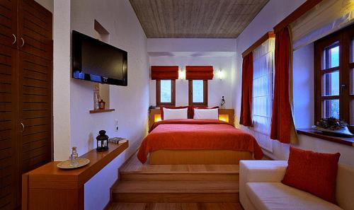 a bedroom with a red bed and a couch at Kerasies Guesthouse in Vovousa
