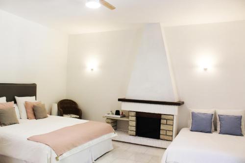 - 2 lits dans une chambre avec cheminée dans l'établissement Le Mas Des Alizés, à La Colle-sur-Loup