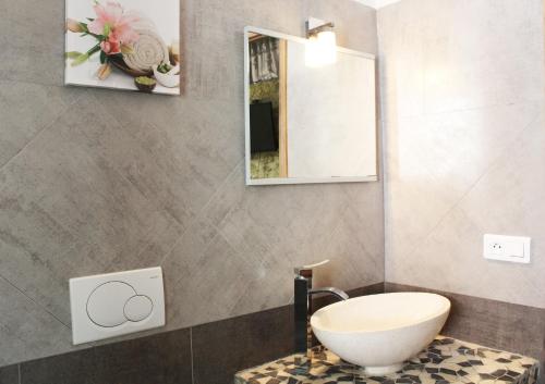 bagno con lavandino bianco e specchio di Le Mas Des Alizés a La Colle-sur-Loup