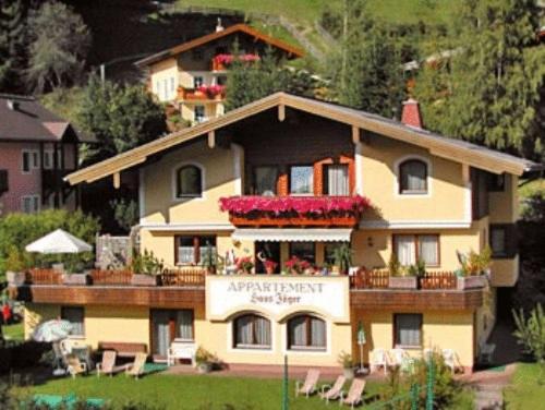 a large building with a balcony with flowers on it at Appartements Landhaus Jäger in Filzmoos
