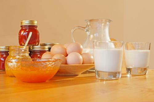 a table with two glasses of milk and a bowl of eggs at Fassnauerhof Ridnaun in Racines