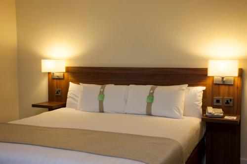 uma cama num quarto de hotel com duas lâmpadas em Holiday Inn Glasgow - East Kilbride, an IHG Hotel em East Kilbride