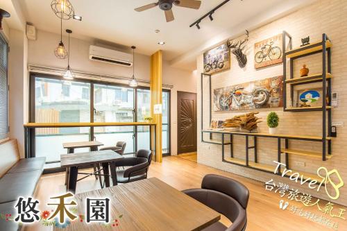 a restaurant with tables and chairs in a room at Host Garden悠禾園 in Hualien City