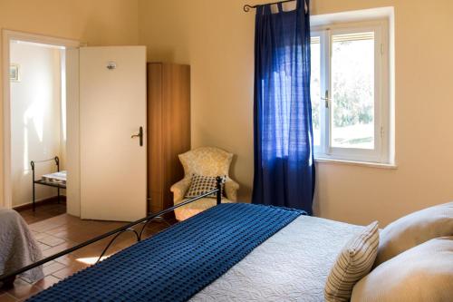 a bedroom with a bed and a window and a chair at Villa Elisabetta in Trequanda