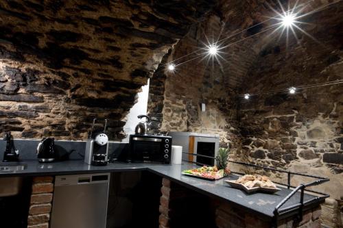a kitchen with a counter in a brick wall at Bed&Bike Prachatice in Prachatice
