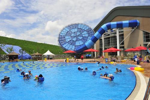 a group of people in a swimming pool with a water slide at Holiday Inn & Suites Alpensia Pyeongchang Suites, an IHG Hotel in Pyeongchang