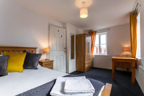 een slaapkamer met een bed, een bureau en een raam bij Watkins House by Cliftonvalley Apartments in Cardiff