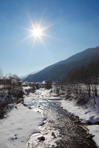 a river with snow and the sun in the sky at Fassnauerhof Ridnaun in Racines