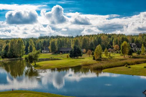 a view of a golf course with a lake at Hotel Lipowy Most in Supraśl