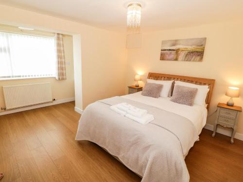 a bedroom with a large bed and a window at Llain Mai in Llangefni