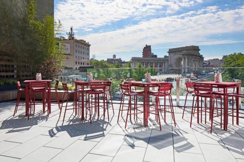 a row of tables with chairs and umbrellas at Hotel 50 Bowery, part of JdV by Hyatt in New York