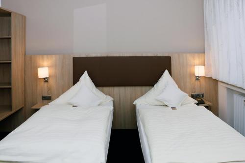 two beds sitting next to each other in a room at Hotel Restaurant Vogt in Rietberg