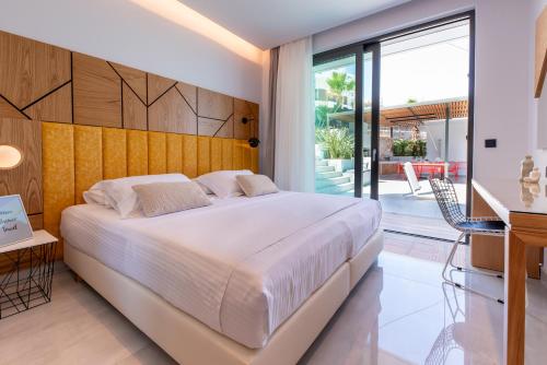 a bedroom with a large bed and a balcony at Villa Lydia I Superb views, two pools, next to the city in Kissamos