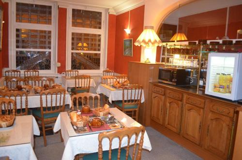 a restaurant with tables and chairs and a kitchen at Hotel Central Anzac in Amiens