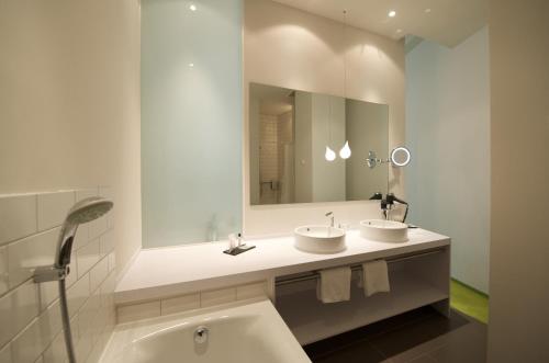 ein Badezimmer mit zwei Waschbecken und einem großen Spiegel in der Unterkunft Wyndham Garden Berlin Mitte in Berlin