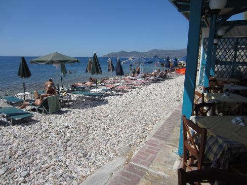 a group of people on a beach with umbrellas at Hotel Tarsanas in Pythagoreio