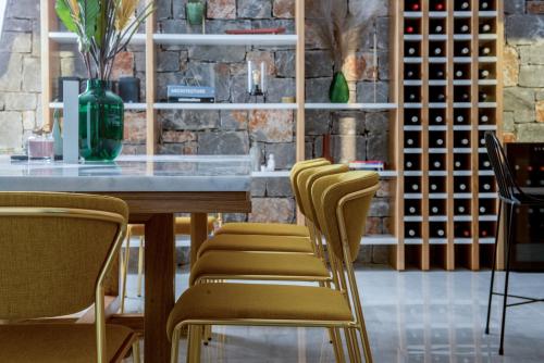 a dining room with a table and chairs and wine racks at Villa Lydia I Superb views, two pools, next to the city in Kissamos