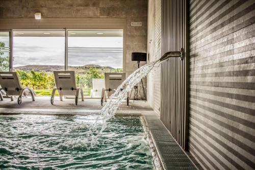 una piscina con una fuente de agua en una casa en Hotel Spa Tudanca Aranda, en Aranda de Duero