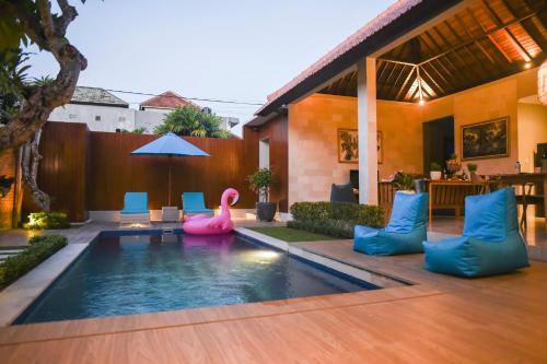 einen Pool mit zwei rosa Flamingos im Hinterhof in der Unterkunft Haneirich Bali Villa in Canggu