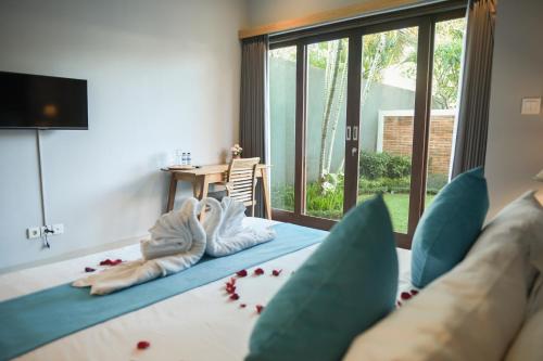 ein Schlafzimmer mit einem Bett mit blauen Kissen in der Unterkunft Haneirich Bali Villa in Canggu
