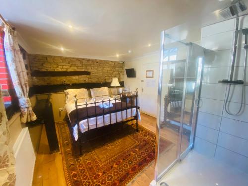 een slaapkamer met een bed en een glazen douche bij The Old Court Hotel in Witney