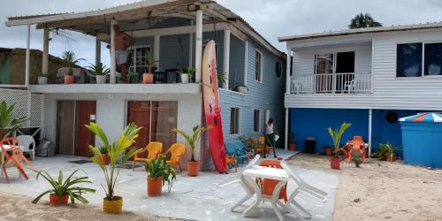 uma casa na praia com cadeiras e uma prancha de surf em Sunny Beach Apartments em San Andrés