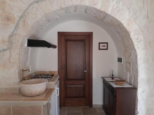 a bathroom with a sink and a wooden door at B&B Masseria Nardelli in Locorotondo