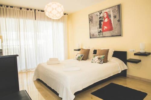 um quarto com uma cama branca e uma grande janela em Espacioso apartamento en Guadalmina - Marbella em Marbella
