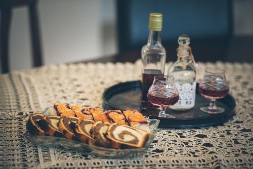 a table with a plate of food and two glasses of wine at Casa Ilies in Galeş