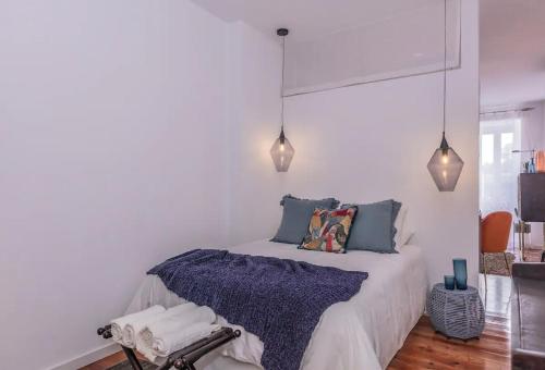 a bedroom with a bed with blue pillows and lights at Luxury Beato Trendy Location in Lisbon