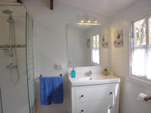 een witte badkamer met een wastafel en een douche bij Cottage Bougainville in La Orotava