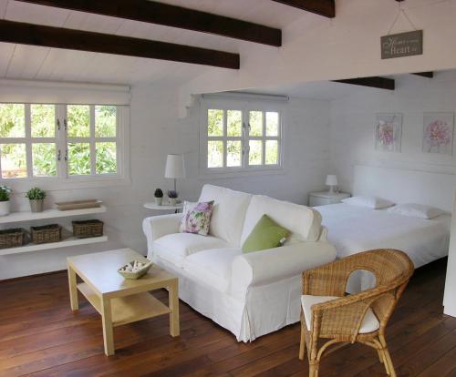 een woonkamer met een witte bank en een tafel bij Cottage Bougainville in La Orotava