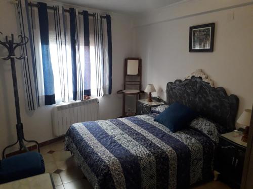 1 dormitorio con 1 cama con manta azul y blanca en Casa Rosalia, en Bronchales