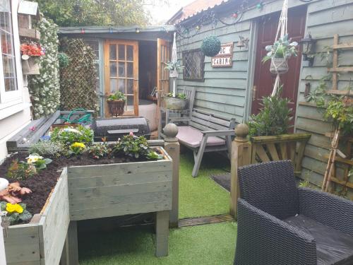 a garden with a bench and a table and chairs at Chalet with hot tub room in Clanfield