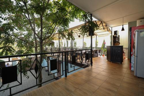 a balcony with a table and chairs and a tree at Hotel Capri in Sukhum