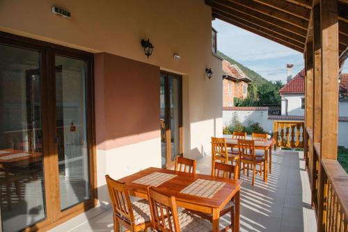 a patio with wooden tables and chairs on a balcony at Casa Ilies in Galeş
